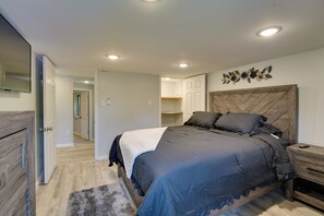 A bedroom with a large bed, a nightstand, a dresser, and a mirror. - Stylish Harveys Lake Apt - Steps to the Water! (Harveys Lake)