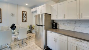 A modern kitchen with white cabinets, stainless steel appliances, and a marble backsplash. - Stylish Harveys Lake Apt - Steps to the Water! (Harveys Lake)