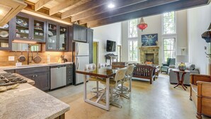 Una cocina amplia con electrodomésticos modernos, un comedor con mesa y sillas de madera, y una sala de estar acogedora con chimenea.