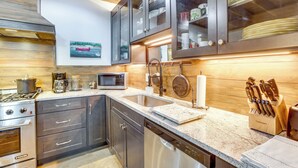 Una cocina moderna con electrodomésticos de acero inoxidable, encimera de granito y armarios de madera.