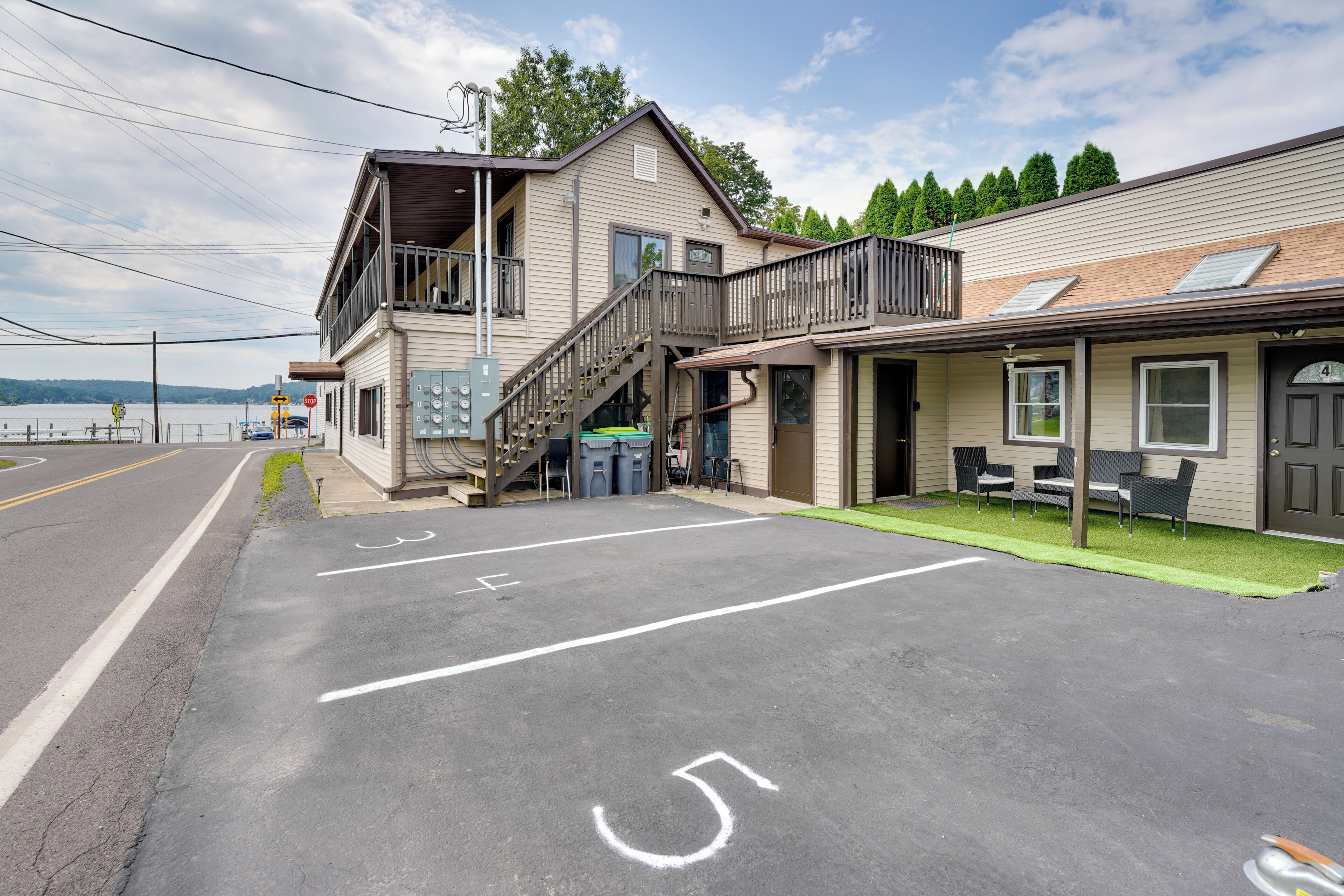 A two-story building with a balcony, a covered outdoor seating area, and a parking lot with handicapped accessibility markings.