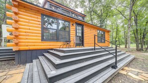 A log cabin with a wooden deck and steps leading to the entrance. - Mcalester Vacation Rental w/ Private Hot Tub (McAlester)