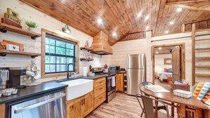 A modern kitchen with wooden cabinets, stainless steel appliances, and a large window. - Mcalester Vacation Rental w/ Private Hot Tub (McAlester)