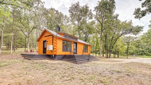 A log cabin with a raised platform and steps leading to the entrance. - Mcalester Vacation Rental w/ Private Hot Tub (McAlester)