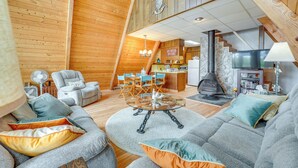 A cozy log cabin interior with a dining area, a fireplace, and a television. - Long Lake Cabin w/ Kayaks, Private Beach & Dock! (Fountain)