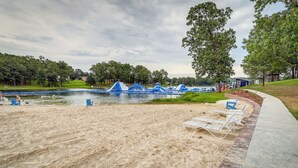 A sandy beach area with a water body, blue play structures, and a pathway with chairs. - Lakefront Horseshoe Bend Home w/ Boat Dock! (Horseshoe Bend)