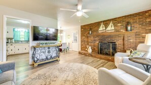 A living room with a fireplace, a ceiling fan, and a television. - Charming Jonesville Home w/ Grill - Near Wineries! (Jonesville)
