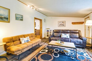 A living room with a sofa, a leather chair, a coffee table, and a rug. - Charming Watkins Glen Home w/ Deck & Yard! (Watkins Glen)