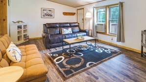 A living room with a brown leather sofa, a wooden coffee table, and a patterned rug. - Charming Watkins Glen Home w/ Deck & Yard! (Watkins Glen)