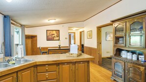 A kitchen with wooden cabinets, a large island, and a built-in wine rack. - Charming Watkins Glen Home w/ Deck & Yard! (Watkins Glen)