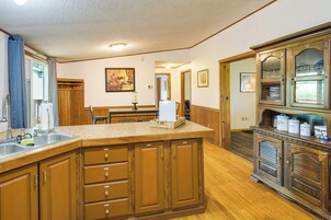 Una cocina con armarios de madera, una isla grande y una estantería empotrada para vinos.