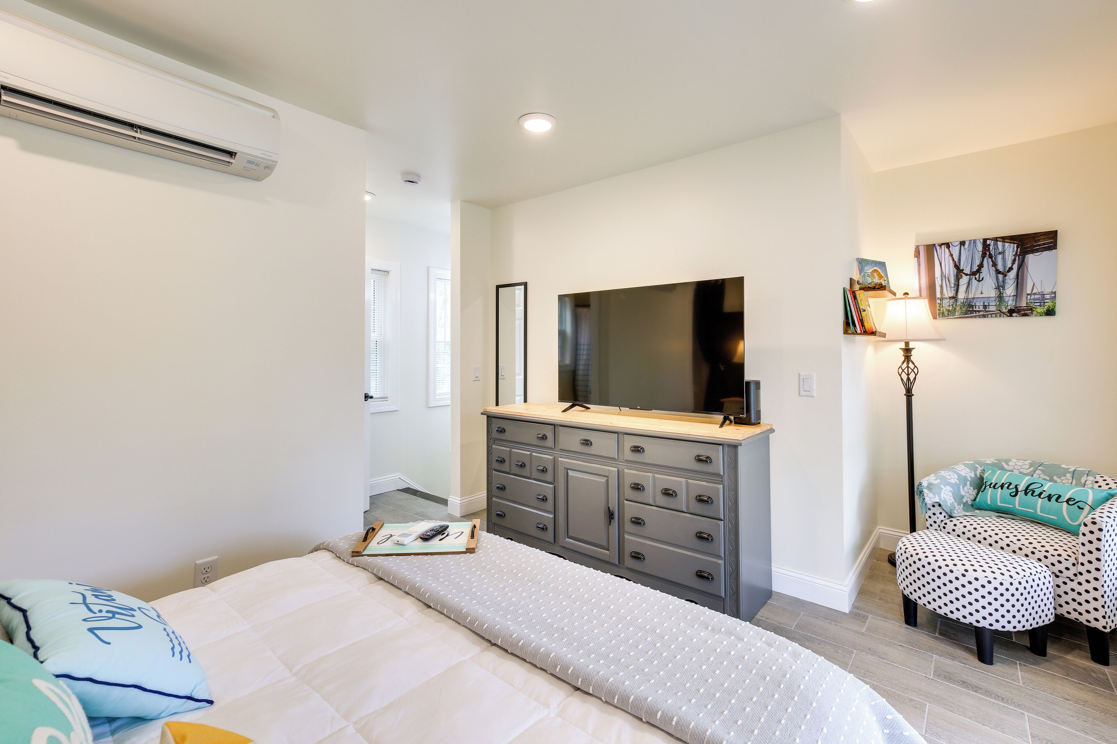 A bedroom with a bed, dresser, and chair.