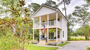 A two-story house with a porch, a flag, and a lawn. - Cozy Cottage: Minutes to Downtown Southport! (Southport)