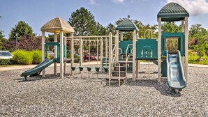A playground with slides and climbing structures, surrounded by gravel and greenery. - Furnished Outdoor Space: Family Home in Ocean View (Ocean View)