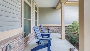 A covered porch with two Adirondack chairs and a small turtle on the ground. - Furnished Outdoor Space: Family Home in Ocean View (Ocean View)