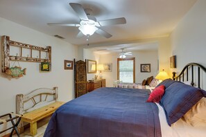 A bedroom with a large bed, a wooden bench, a ceiling fan, and a desk. - Emory Vacation Rental w/ Lake Fork Boat Access! (Emory)