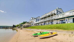 Una playa con dos kayaks y un edificio de varios balcones.