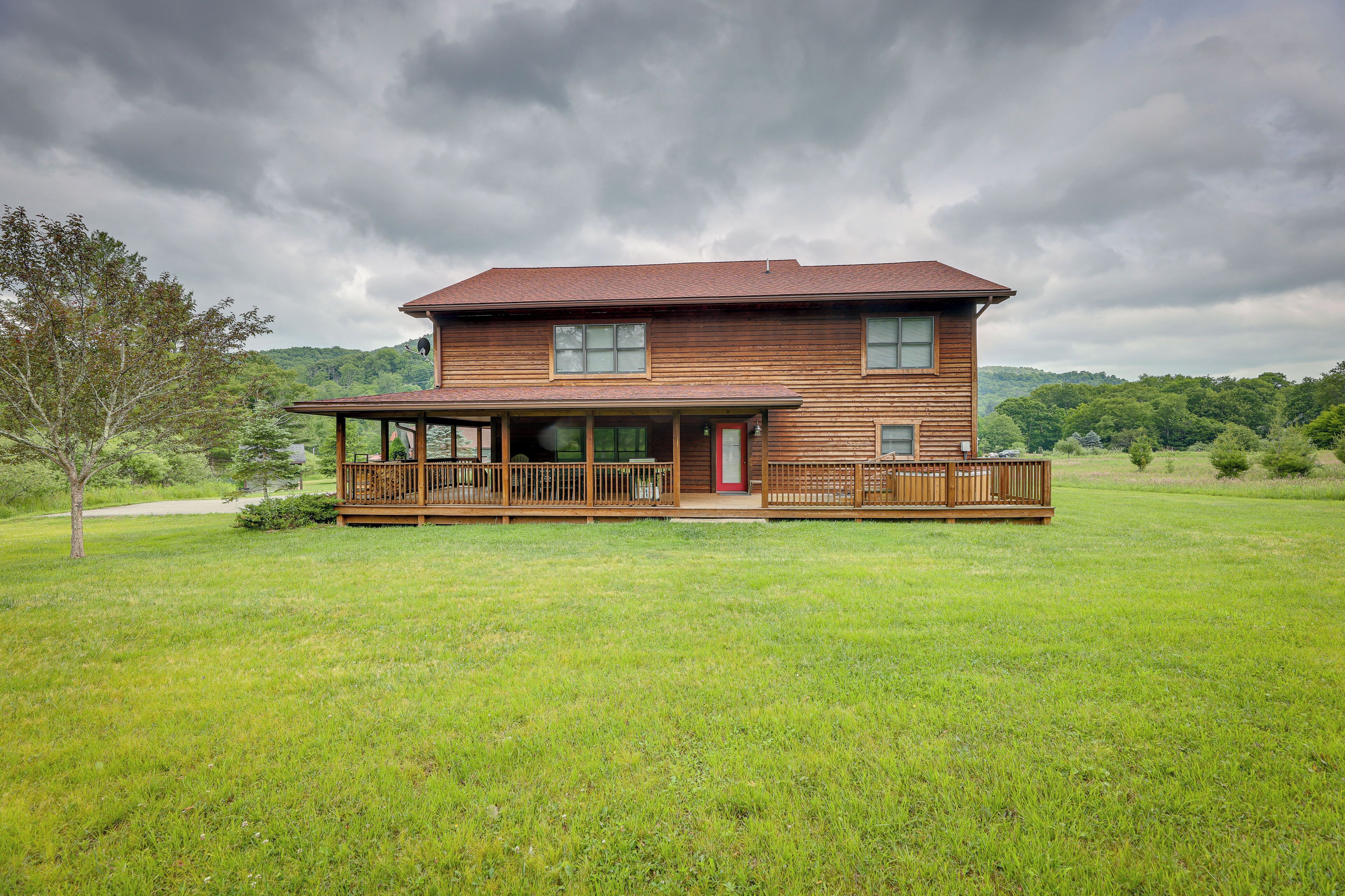 A two-story wooden house with a porch and a fenced deck.