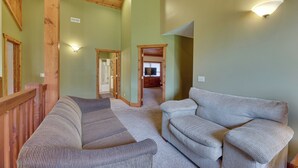 A spacious living area with a wooden ceiling, a large sectional sofa, and a wall-mounted light fixture. - Slaty Fork Home ~ 6 Mi to Snowshoe Mountain Resort (Snowshoe)