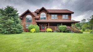 A two-story wooden house with a front porch, surrounded by a well-maintained lawn and various shrubs. - Slaty Fork Home ~ 6 Mi to Snowshoe Mountain Resort (Snowshoe)