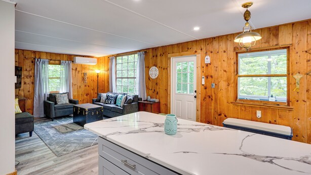 A modern kitchen with a marble countertop, wooden walls, and a dining area with a bench. - Monterey Haven < 1/2 Mi to Lake Garfield w/ Kayaks (Monterey)