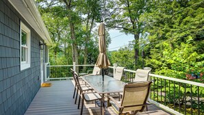 A deck with a glass-top table and chairs, surrounded by a white railing, set against a backdrop of lush greenery. - Monterey Haven < 1/2 Mi to Lake Garfield w/ Kayaks (Monterey)