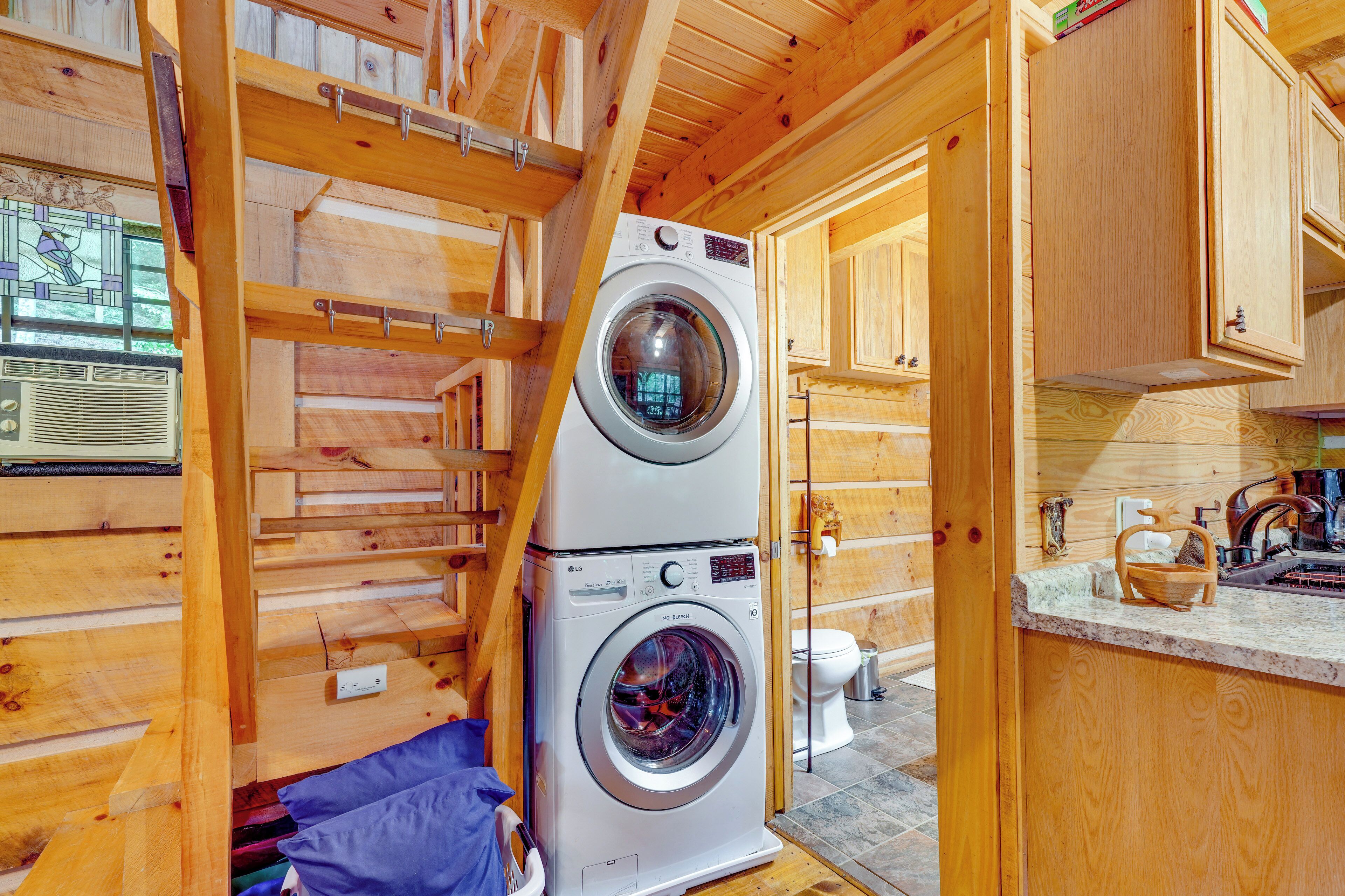 Een kleine wasruimte met een voorlader wasmachine en een klein wasbakje.