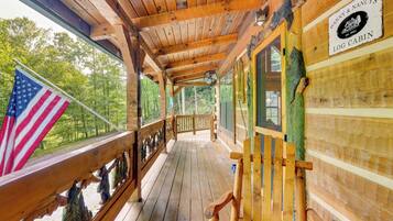 A wooden cabin with a porch, an American flag, and a sign reading "Danny & Nancy's Log Cabin."