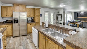 A kitchen with wooden cabinets, stainless steel appliances, granite countertops, and a dishwasher. - Fire Pit & Stunning Lake Views: Shell Knob Home! (Shell Knob)