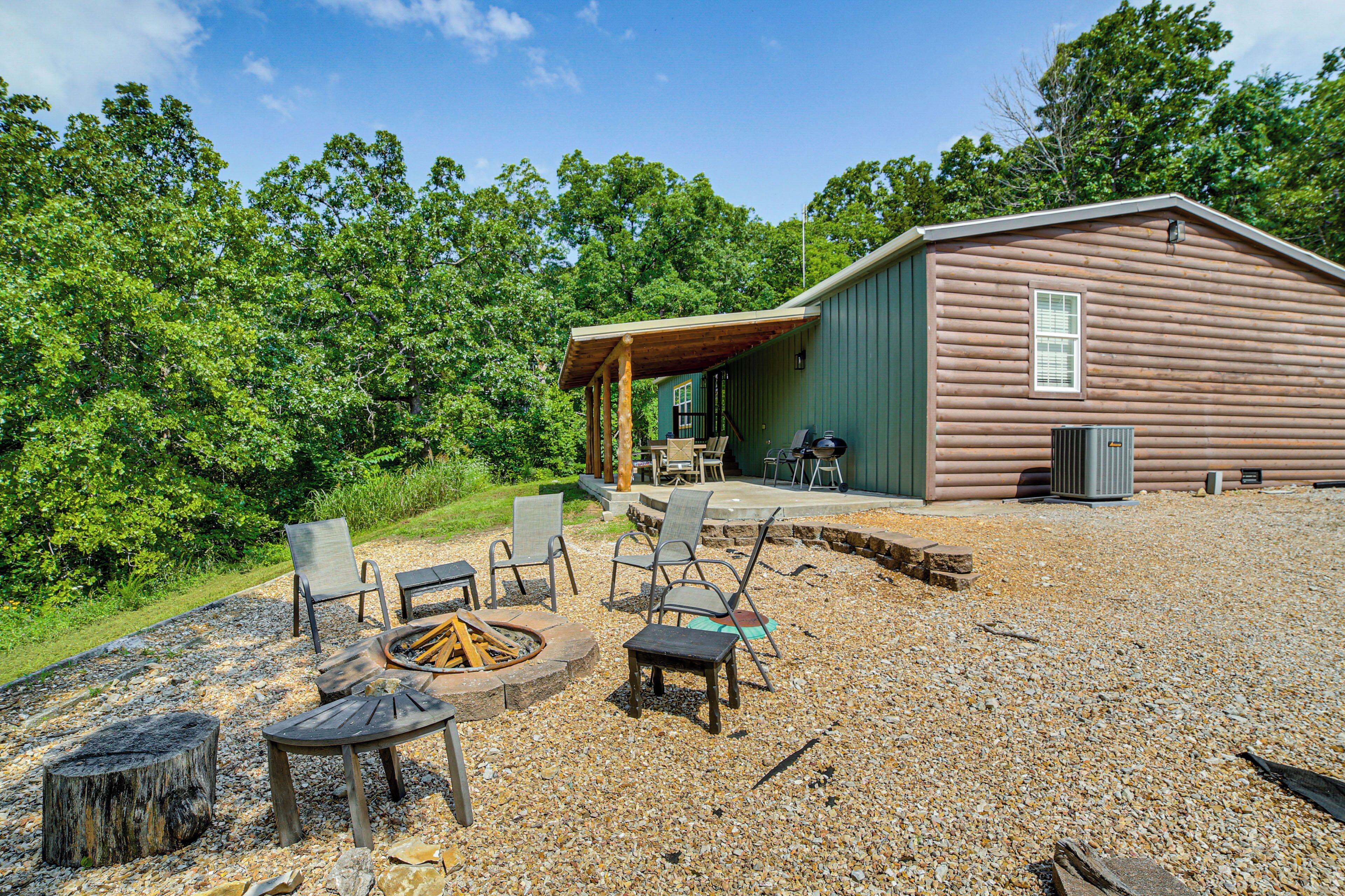 A cabin with a fire pit, outdoor seating, and a covered patio area.
