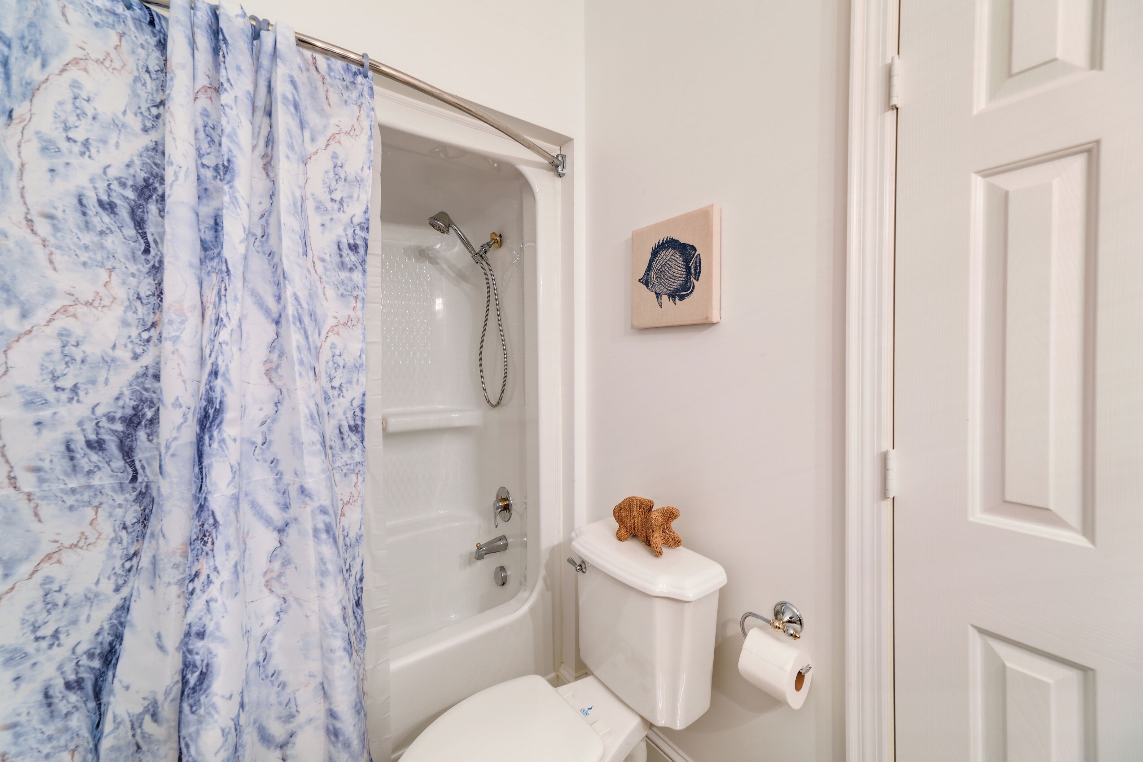 A bathroom with a bathtub, toilet, and shower curtain.
