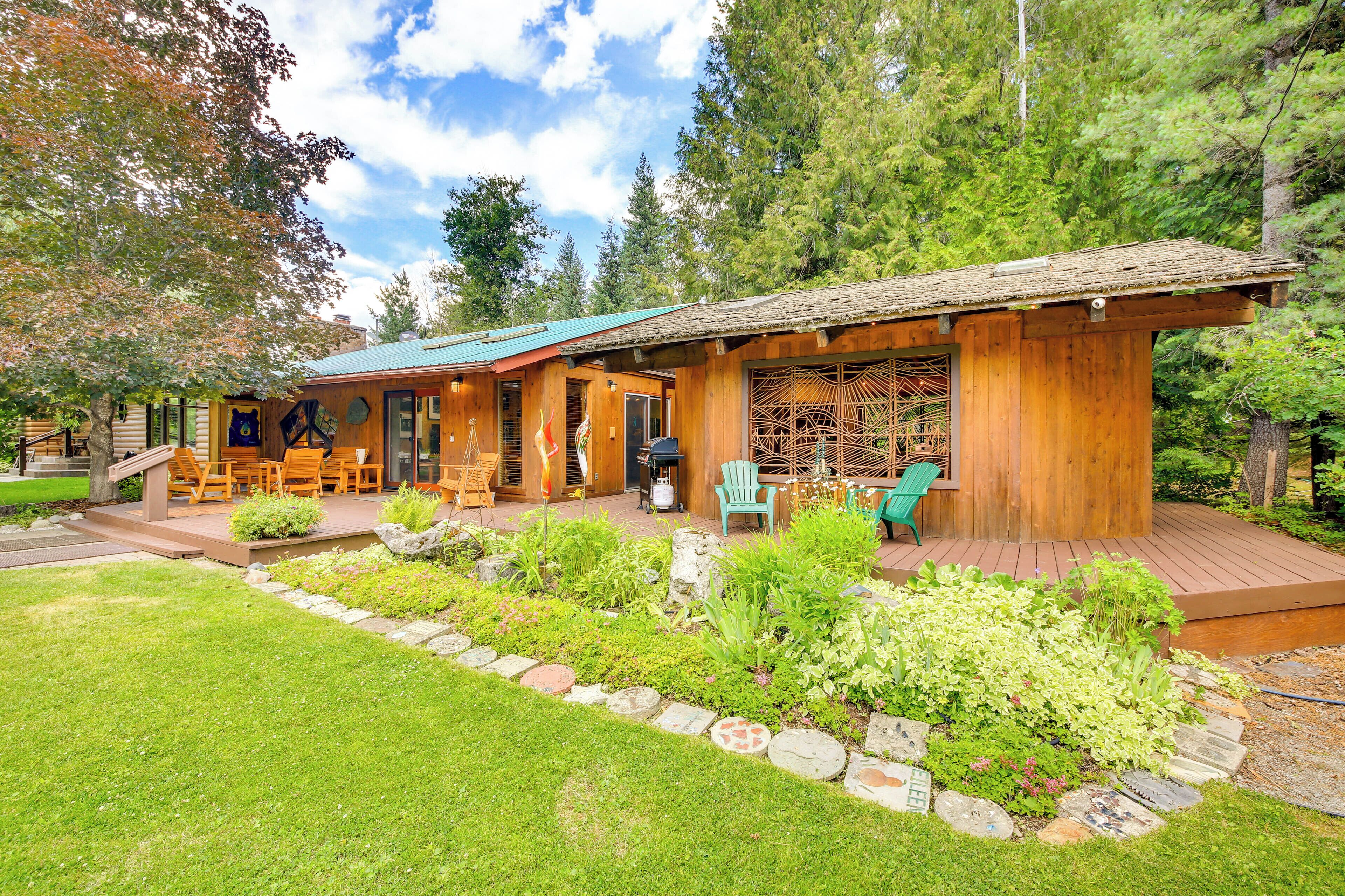 A wooden cabin with a deck, outdoor seating, and a garden.