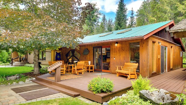 A wooden cabin with a deck, outdoor seating, and a stone pathway. - Unique Nordman Retreat 1 Mi to Priest Lake! (Nordman)