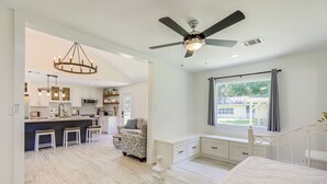 A spacious bedroom with a large bed, a ceiling fan, and a view of the outdoors. - Bright Wallis Cottage w/ Pergola & Grill! (Wallis)