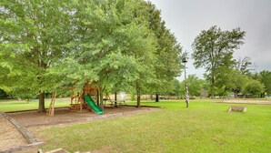 A playground with a slide and climbing structures, surrounded by grass and trees. - Emory Studio Cabin w/ Lake Fork Boat Access! (Emory)