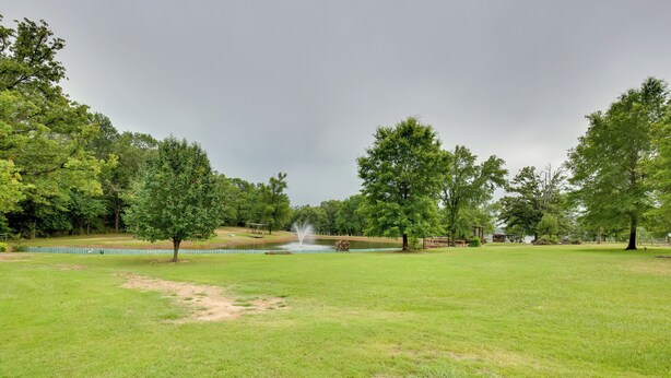 A park with a fountain, trees, and a grassy field. - Emory Studio Cabin w/ Lake Fork Boat Access! (Emory)