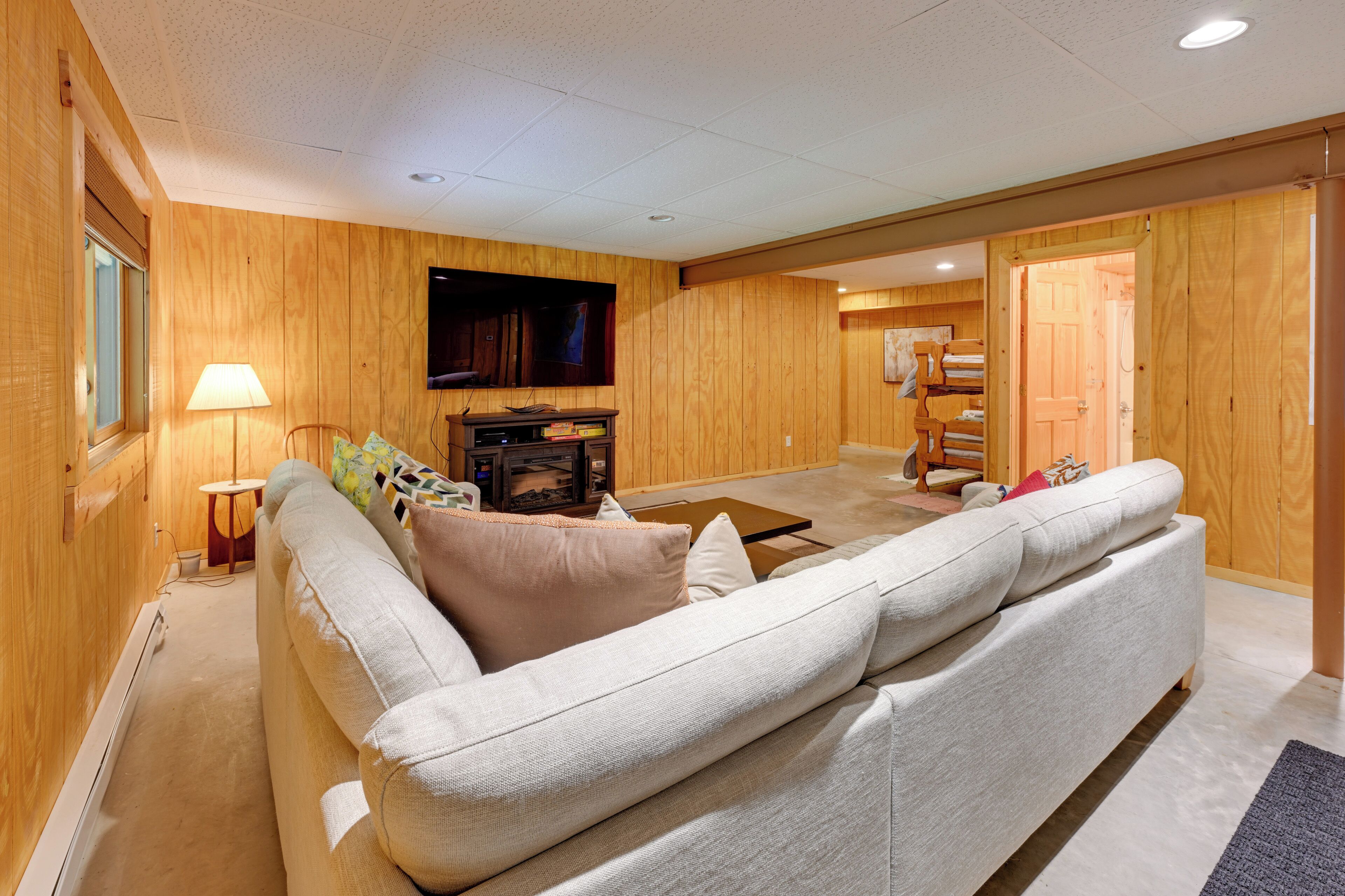 Una sala de estar acogedora con un sofá grande, un televisor y una chimenea.