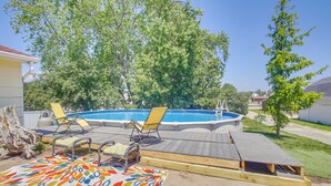 A backyard with a wooden deck, a pool, and two yellow lounge chairs. - Algoma Victorian - Steps to Lake Michigan! (Algoma)