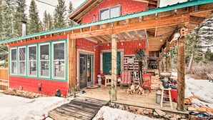 Une cabane en bois rouge, dotée d’un porche, de grandes fenêtres et d’une enseigne accueillante.