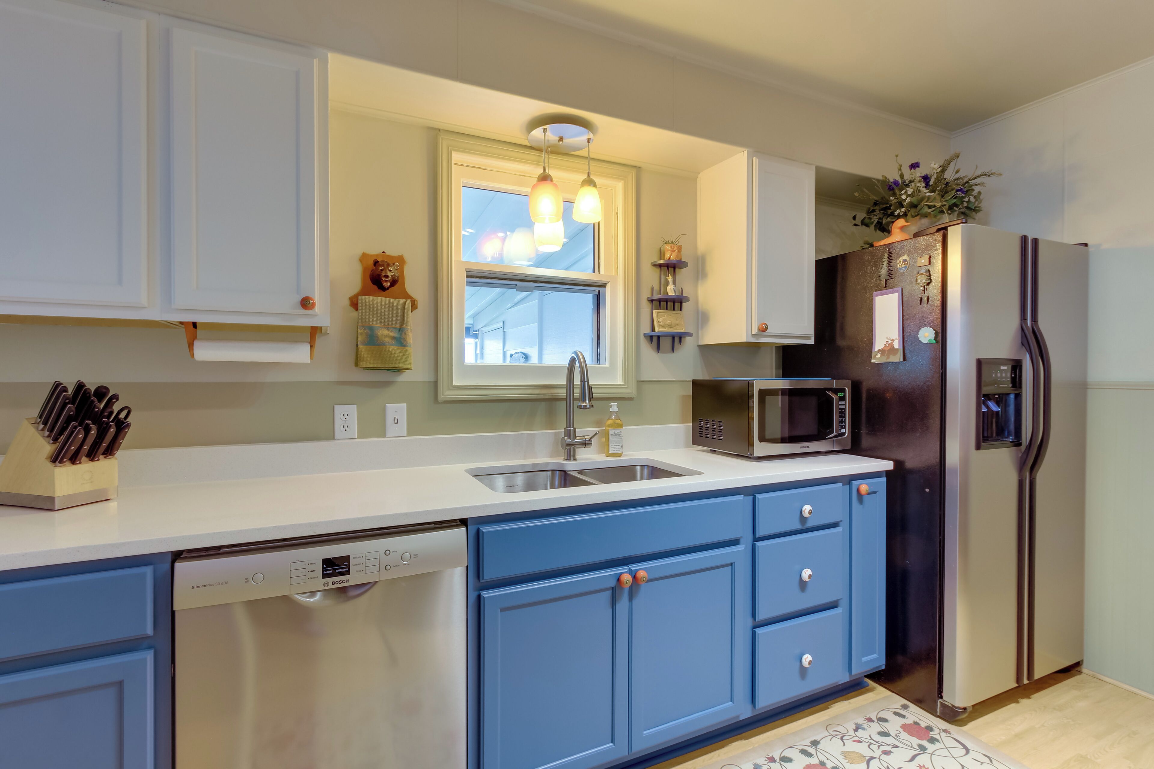 A modern kitchen with a dishwasher, sink, microwave, and refrigerator.