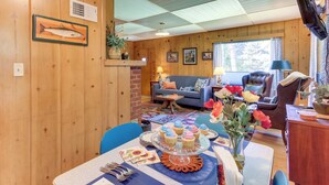 A cozy cabin interior with a dining area, a sofa, and a fireplace. - Peaceful & Scenic Cottage Near Mckenzie River! (Walterville)