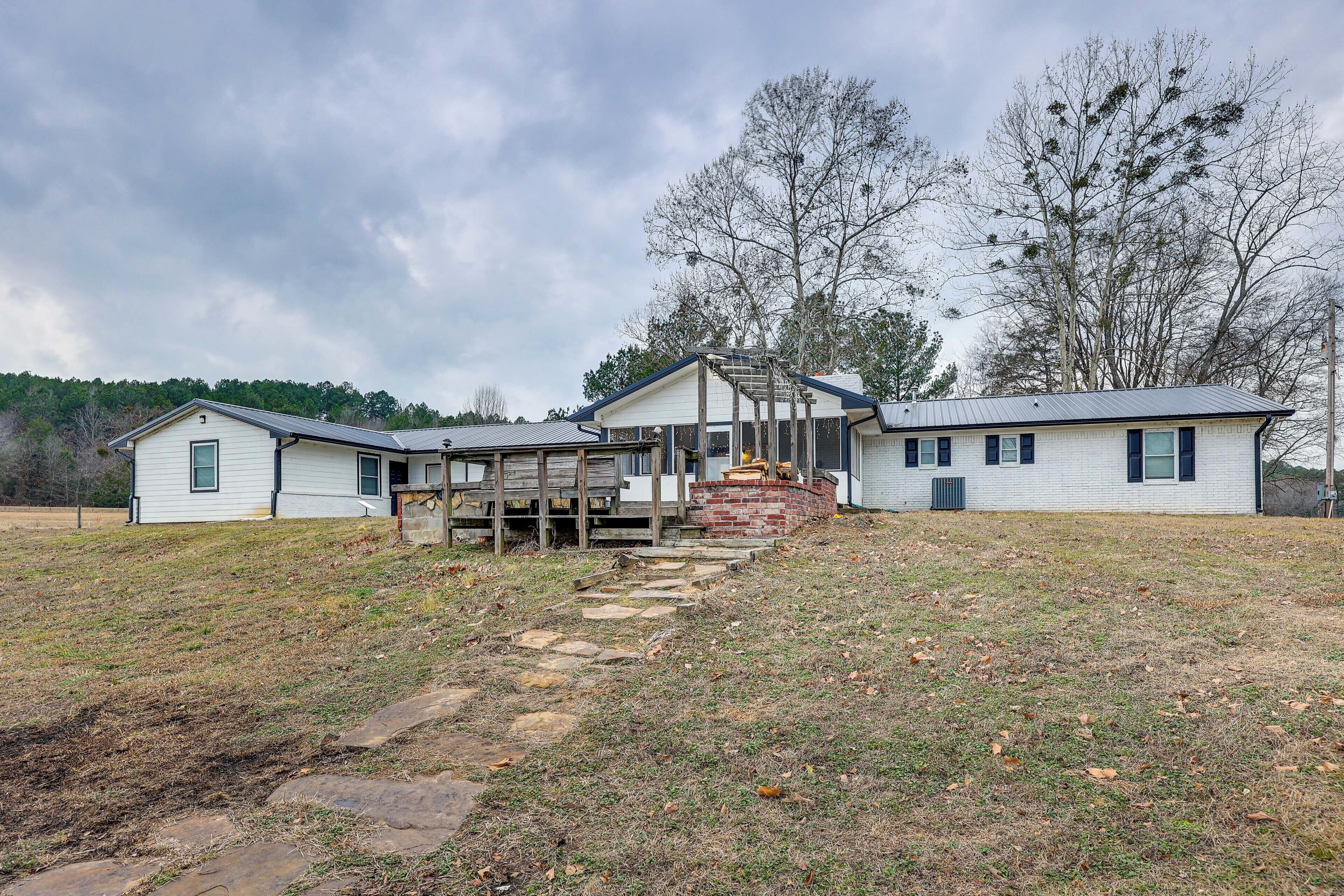 A two-story house with a covered porch and a stone staircase leading to the front door.