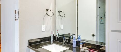 Un baño moderno con un espejo grande, dos lavamanos y un mueble tocador.