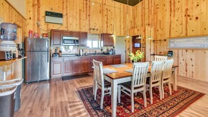 Una cucina con rivestimenti in legno, un'area pranzo, elettrodomestici in acciaio inossidabile e un tappeto grande.