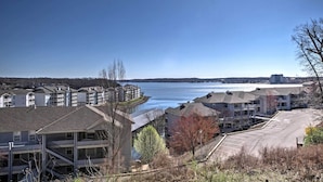 A waterfront residential area with multi-story buildings, a parking lot, and a clear view of the lake. - Lakefront Ozark Getaway w/ Views + Community Perks (Lake Ozark)