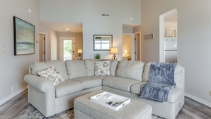 A living room with a sectional sofa, a coffee table, and a rug. - Lakefront Ozark Getaway w/ Views + Community Perks (Lake Ozark)