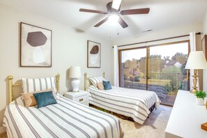A bedroom with two beds, a ceiling fan, a large window with a view, and a desk with a lamp. - Boat Slip + Pool Access: Lake of the Ozarks Condo (Lake Ozark)