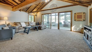 A spacious living room with a high wooden ceiling, a large window, and a cozy seating area. - Delton Oasis Retreat w/ Lake Views & Deck! (Delton)
