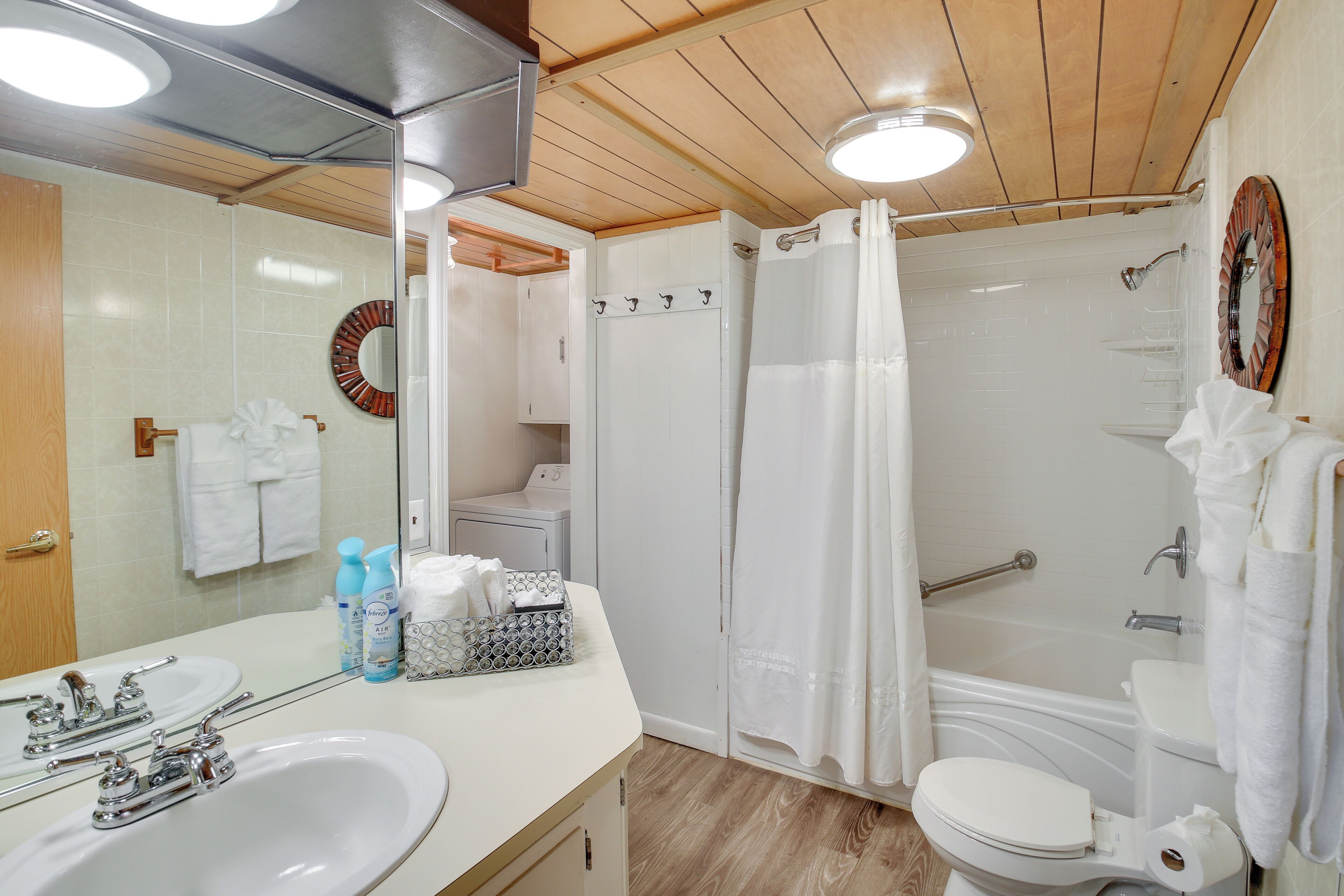 Une salle de bain équipée d’un lavabo, d’un miroir, de toilettes, d’une douche et d’un porte-serviettes.