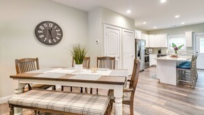 A dining area with a wooden table, chairs, and a clock on the wall. - Chic Spring City Townhome on Watts Bar Lake! (Spring City)